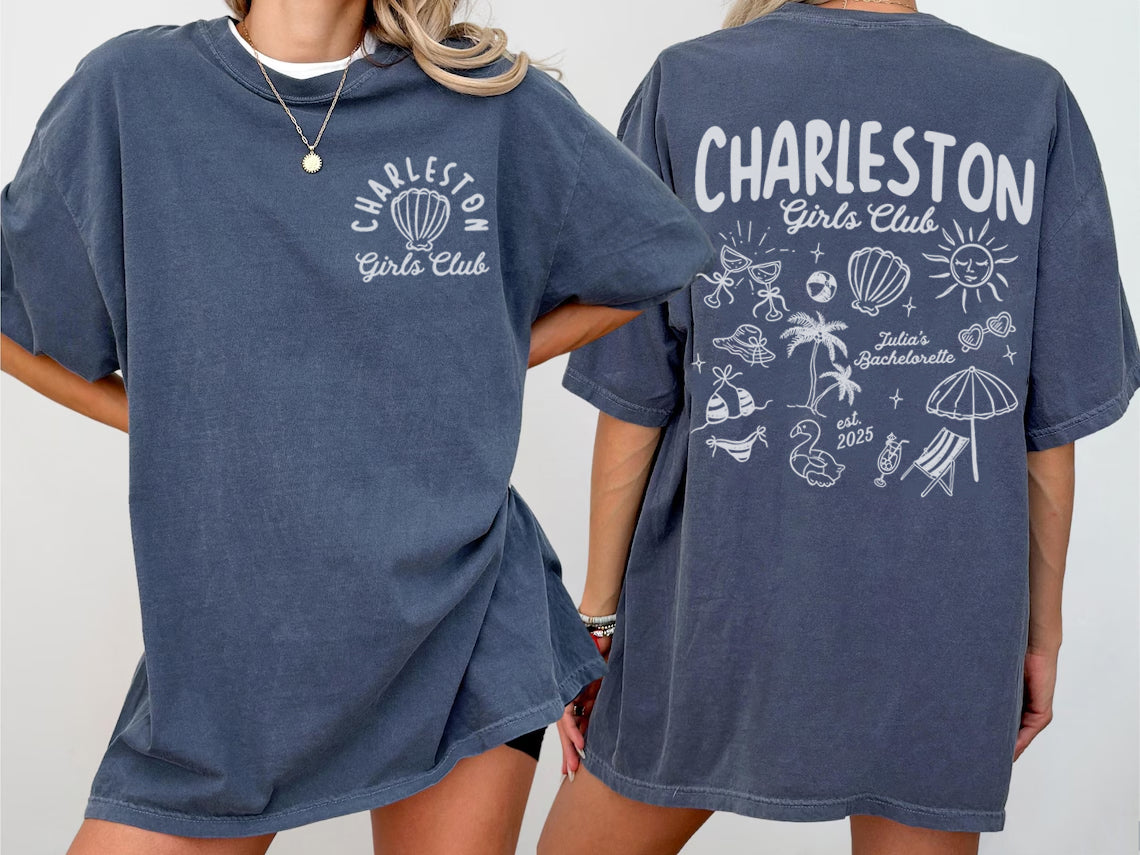 Two people wearing navy blue bachelorette t-shirts with 'Charleston Girls Club' branding on a plain background.