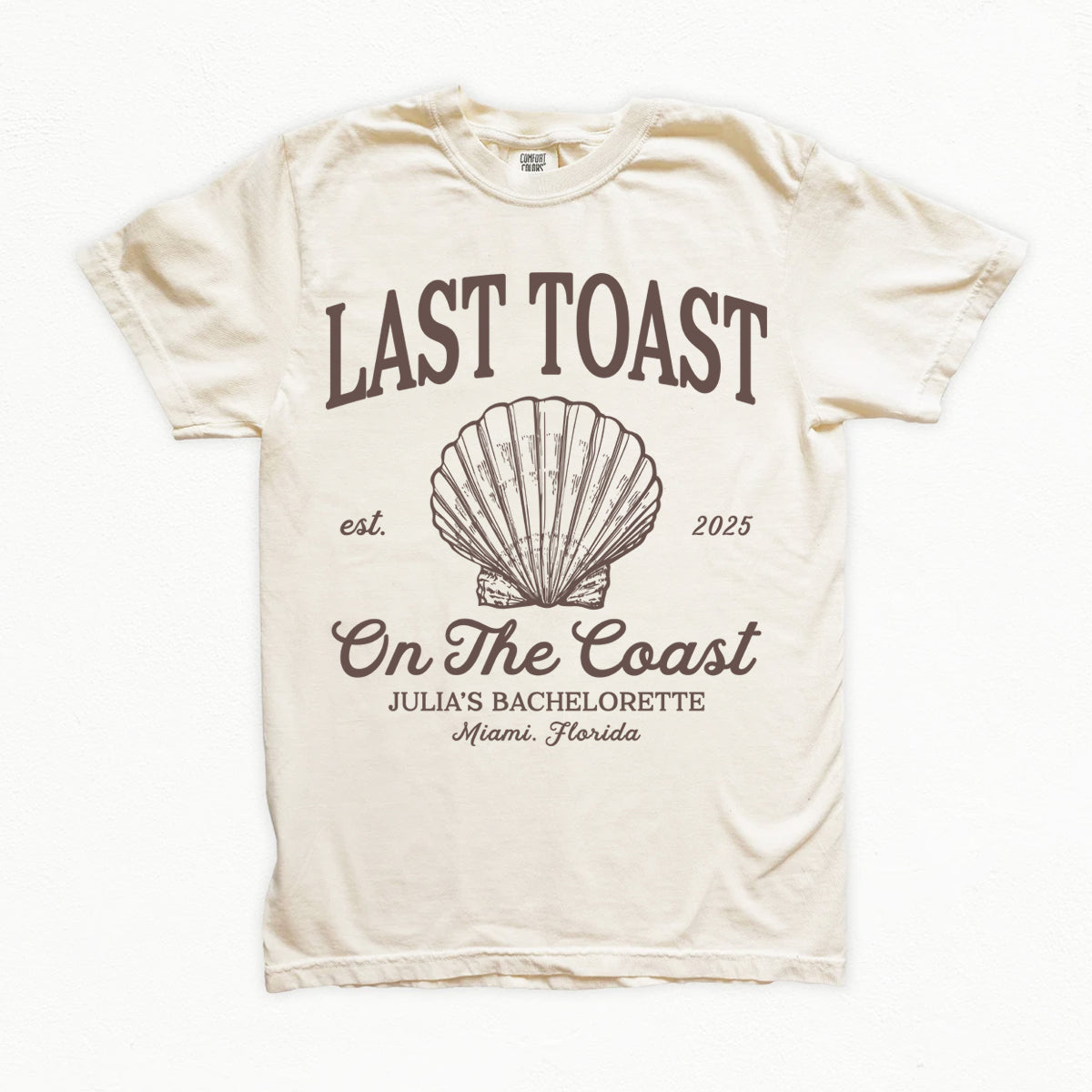 Beige bachelorette t-shirt with 'Last Toast on the Coast' design featuring a shell and text.