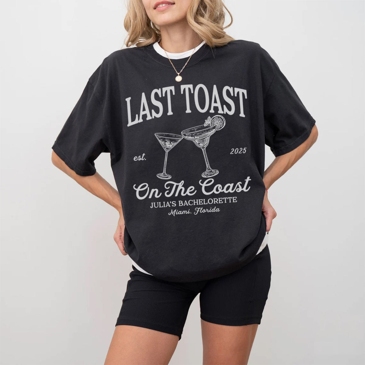 Person wearing a black bachelorette t-shirt with 'Last Toast on the Coast' text and graphics.