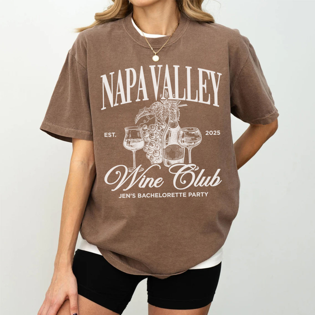 Person wearing a bachelorette brown t-shirt with 'Napa Valley Wine Club' design on a plain background
