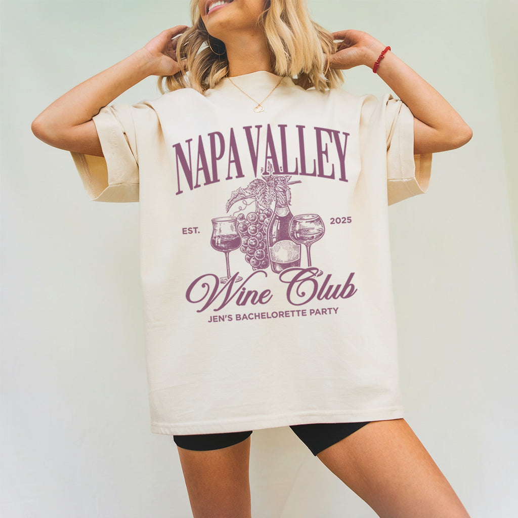 Person wearing a 'Napa Valley Wine bachelorette Club' themed t-shirt with a plain background