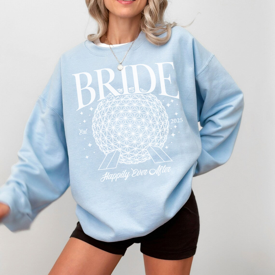 Light blue sweatshirt with 'BRIDE' and 'Happily Ever After' text on a plain background