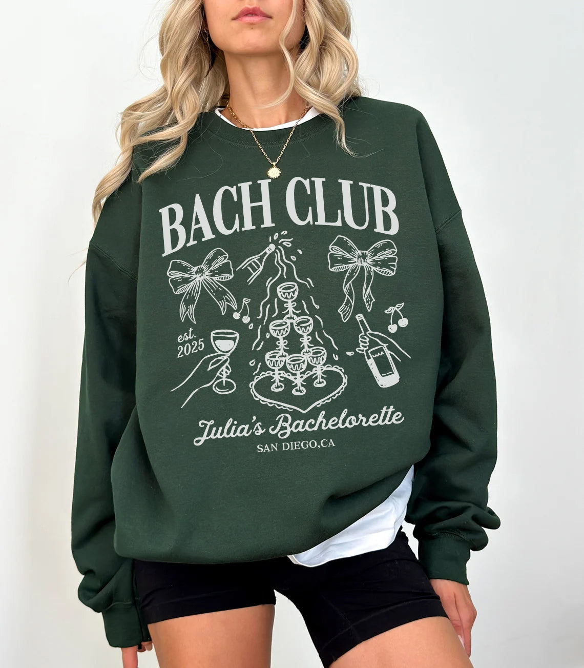 Green sweatshirt with 'BACH CLUB' design and text, worn by a person on a white background